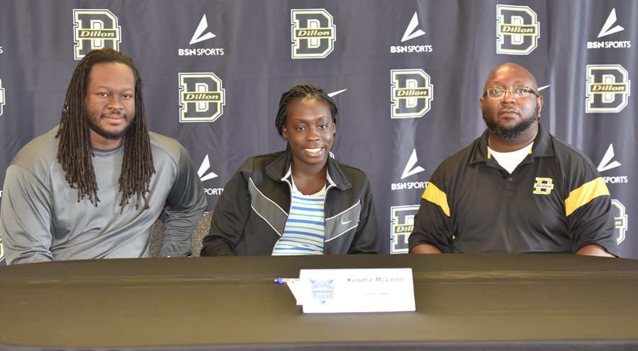 KENDRA McLEOD signs with Coach Lee Page and Coach James McMillan at her side. (Photo by Johnnie Daniels/The Dillon Herald