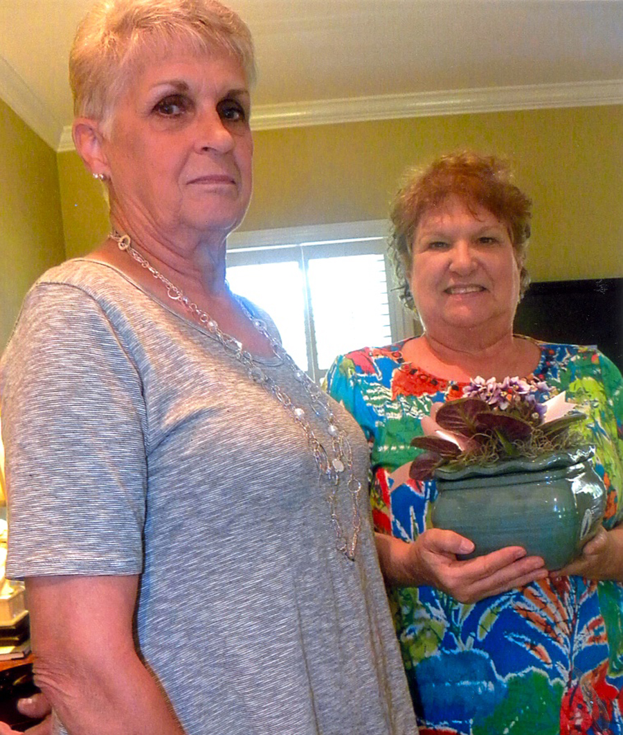 JULIE LeCHETTE presenting a flower pot of violets, our Glove and Trowel Garden Club flower, to Julie Sawyer in appreciation of her service as president the past two years. (Contributed Photo)