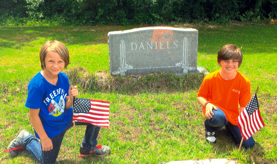 PLACING FLAGS ON GRAVES OF VETERANS—l to r:  Ethan Turner and C. J. Bailey place American flags at Pleasant Grove Baptist Church. Also, Terry Hayes, Garrett Collins of DCS, Sonny Williams and members of Boy Scout Troop 769, Terry Morris, and Janice Morris also assisted placing the American flags throughout Dillon. 